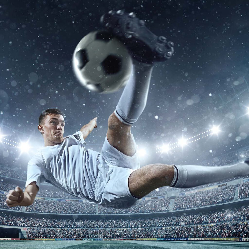 Ein Fußballspieler tritt den Ball in die Luft.